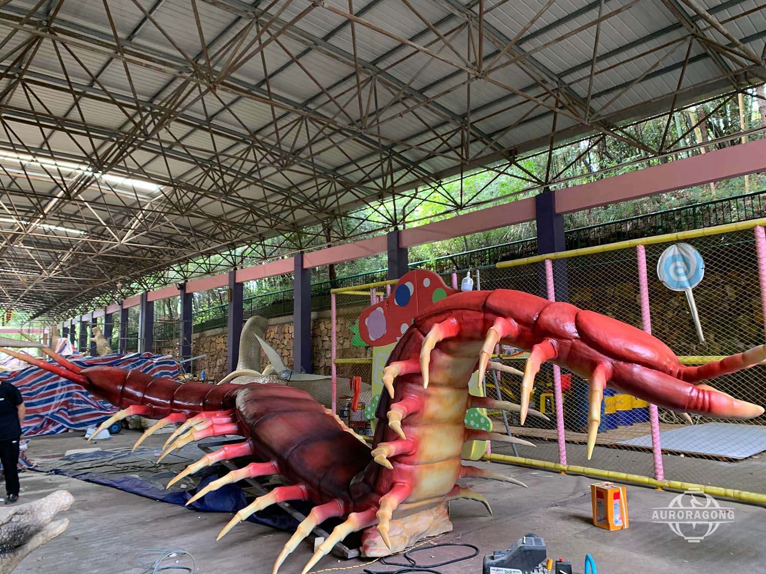 Highly detailed animatronic centipede insect attraction in warehouse