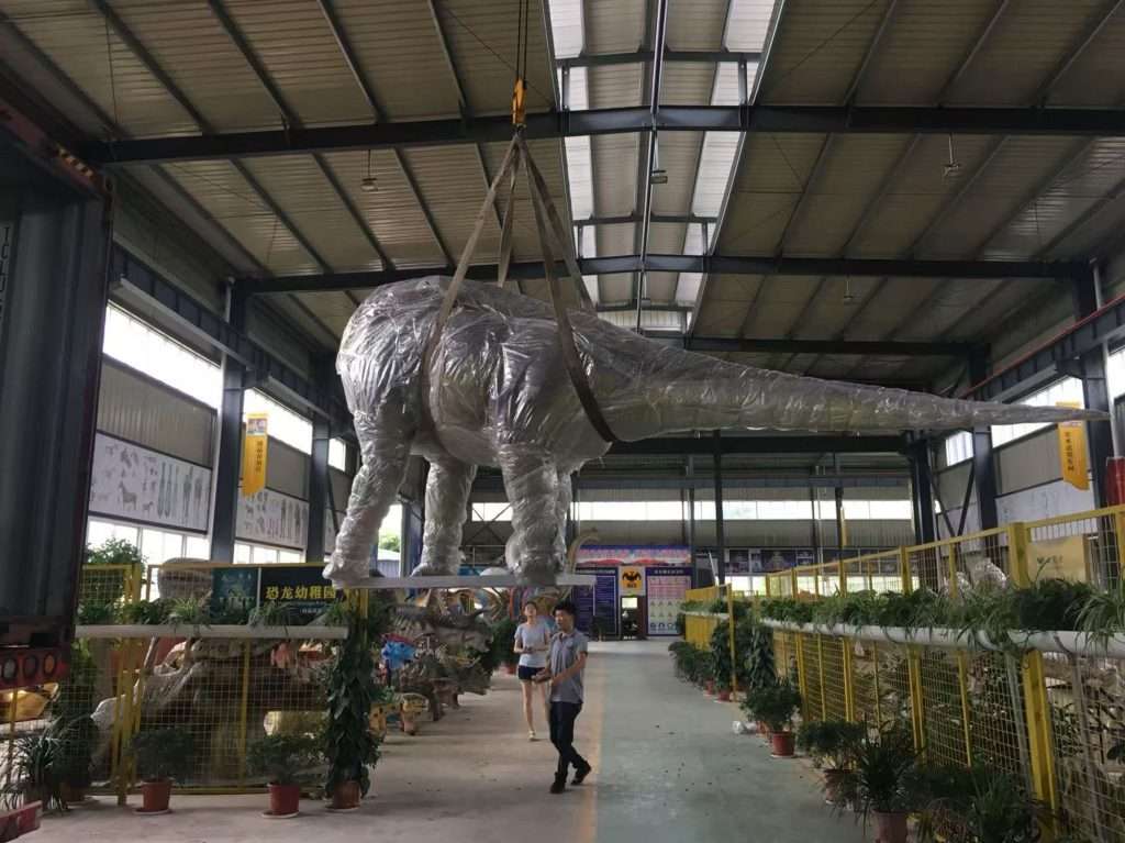 Hoisting the long-necked dinosaur sculpture