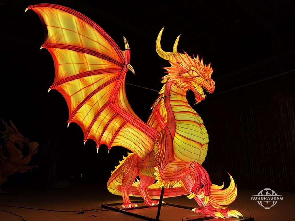 Illuminated red and yellow Western fire dragon lantern with wings spread in full body side view for theme park