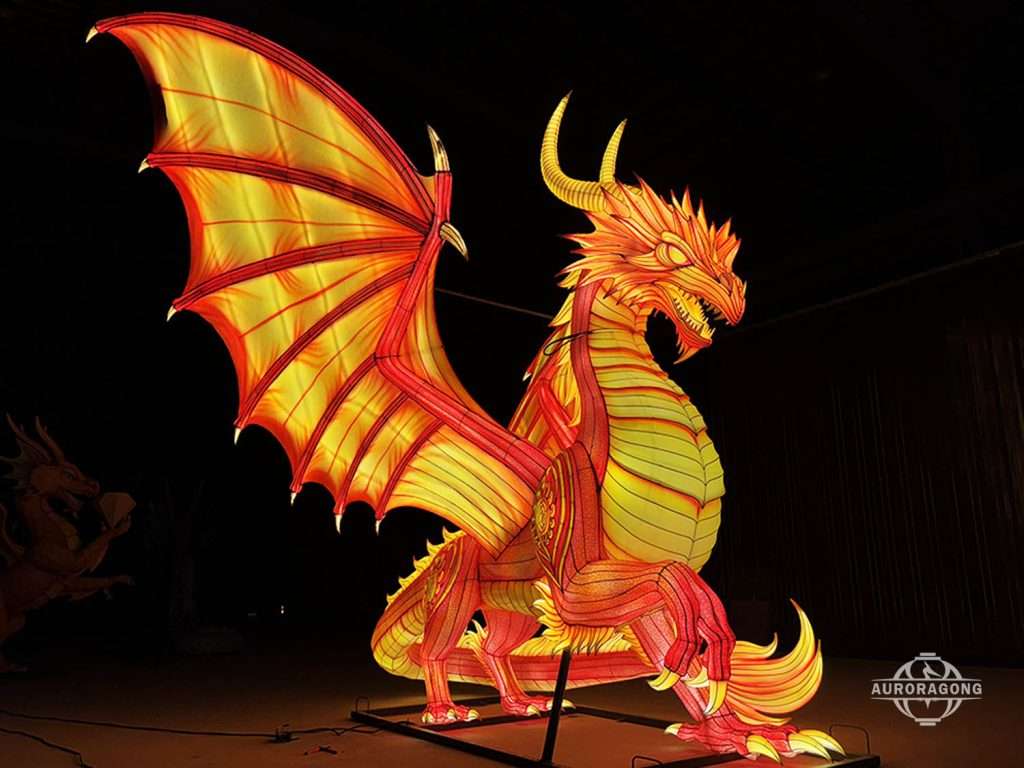 Illuminated red and yellow Western fire dragon lantern with spread wings for theme park display