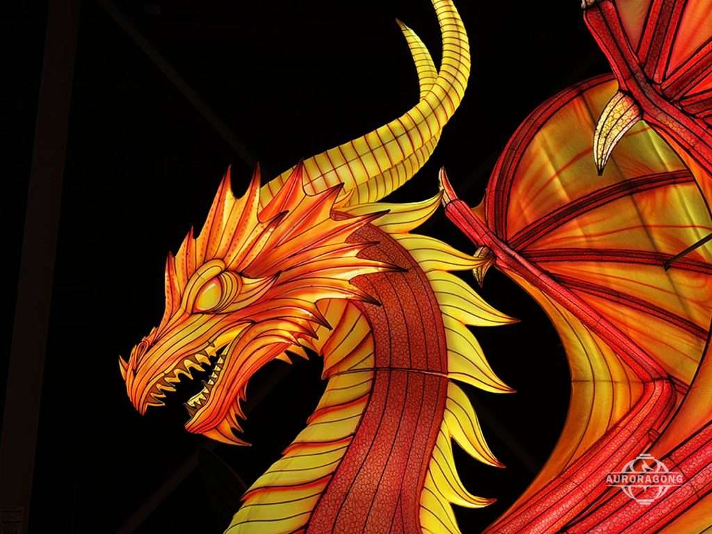 Close-up of illuminated red and yellow Western fire dragon lantern face with detailed scales, teeth, and horns