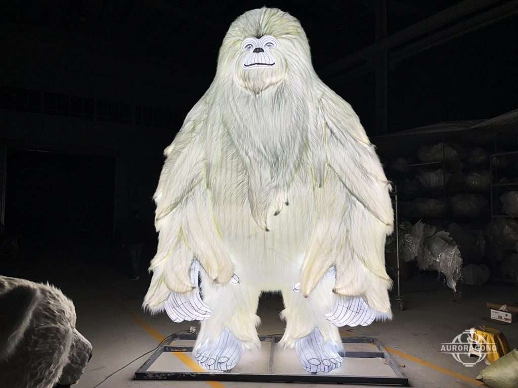 Custom life size realistic yeti snow monster lantern with white fur and detailed facial features in workshop display