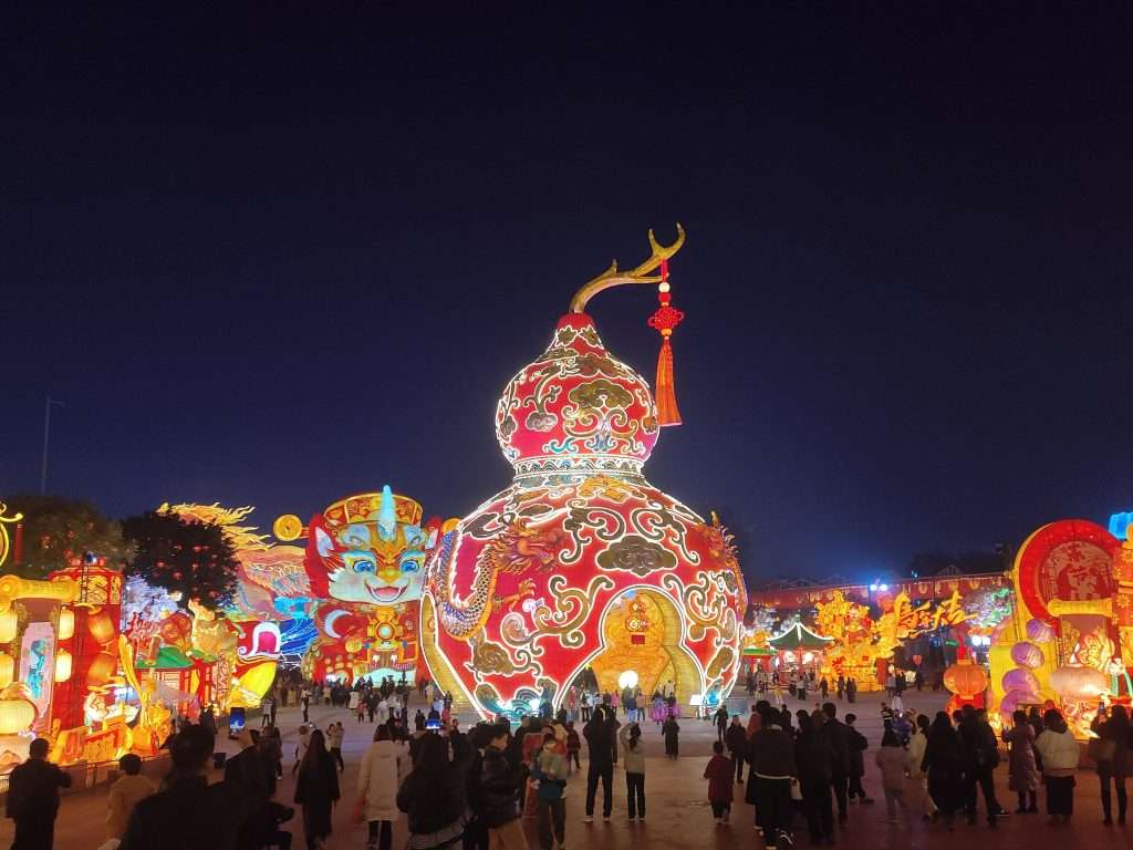 Giant Chinese gourd lantern with lion head decorations and visitors at Zigong International Dinosaur Lantern Festival