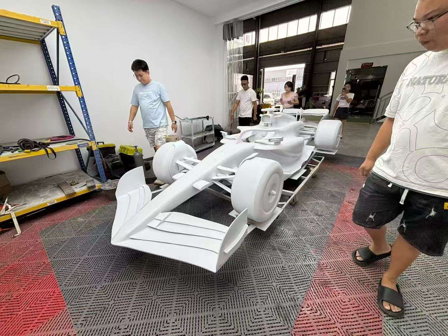 White F1 racing car model in fiberglass production processing in workshop after 3D printing