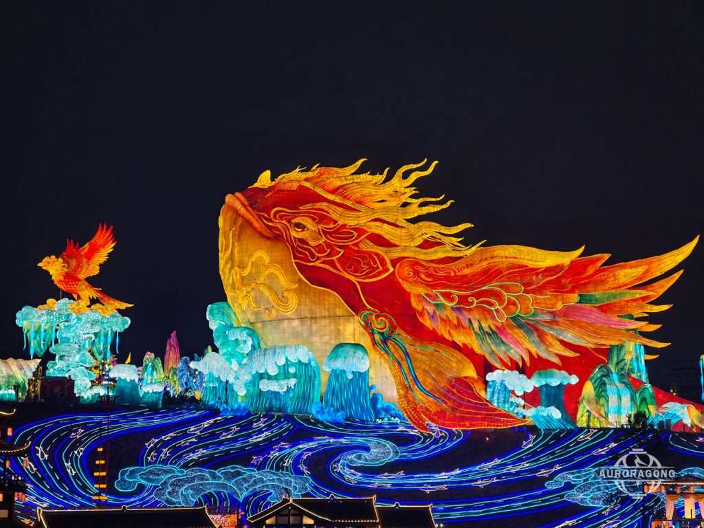 Custom illuminated mythical Kunpeng giant bird lantern with fiery flowing feathers and wave decorations at night festival