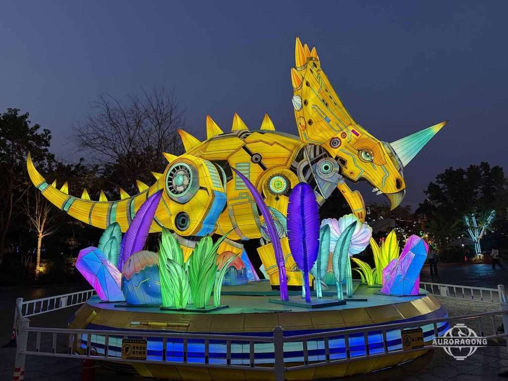 Custom mechanical triceratops lantern with neon yellow and pink accents at theme park night display