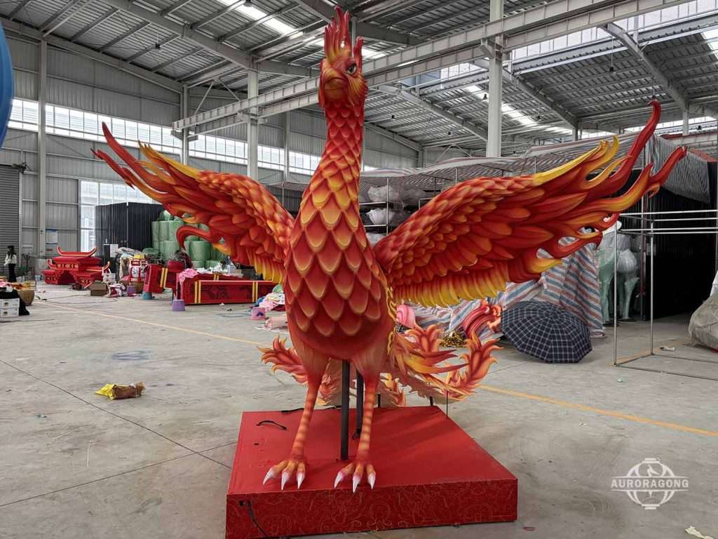 Custom giant red phoenix sculpture lantern with spread wings displayed in workshop or factory setting