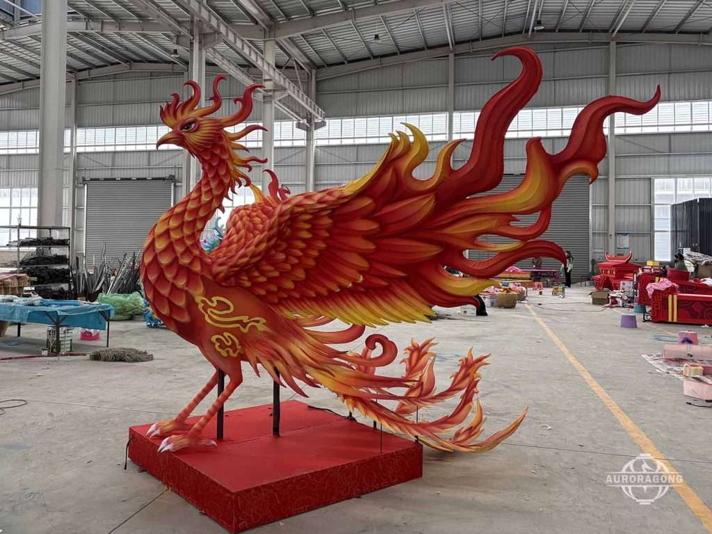 Custom giant red and gold phoenix sculpture lantern with spread wings displayed in factory workshop
