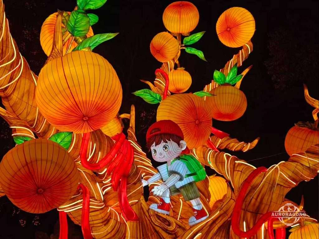 Custom illuminated persimmon tree lantern with boy character climbing among orange fruits and red chili strings at night