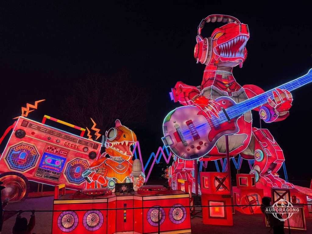Illuminated T-Rex dinosaur lantern holding a guitar with speakers in a rock band display