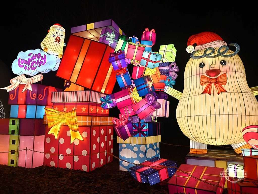 Cute character lantern with Christmas hat holding colorful gift boxes for holiday display