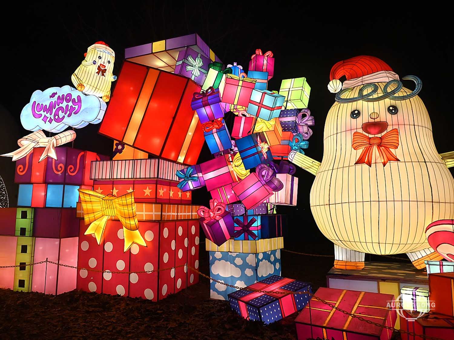 Cute character lantern with Christmas hat holding colorful gift boxes for holiday display