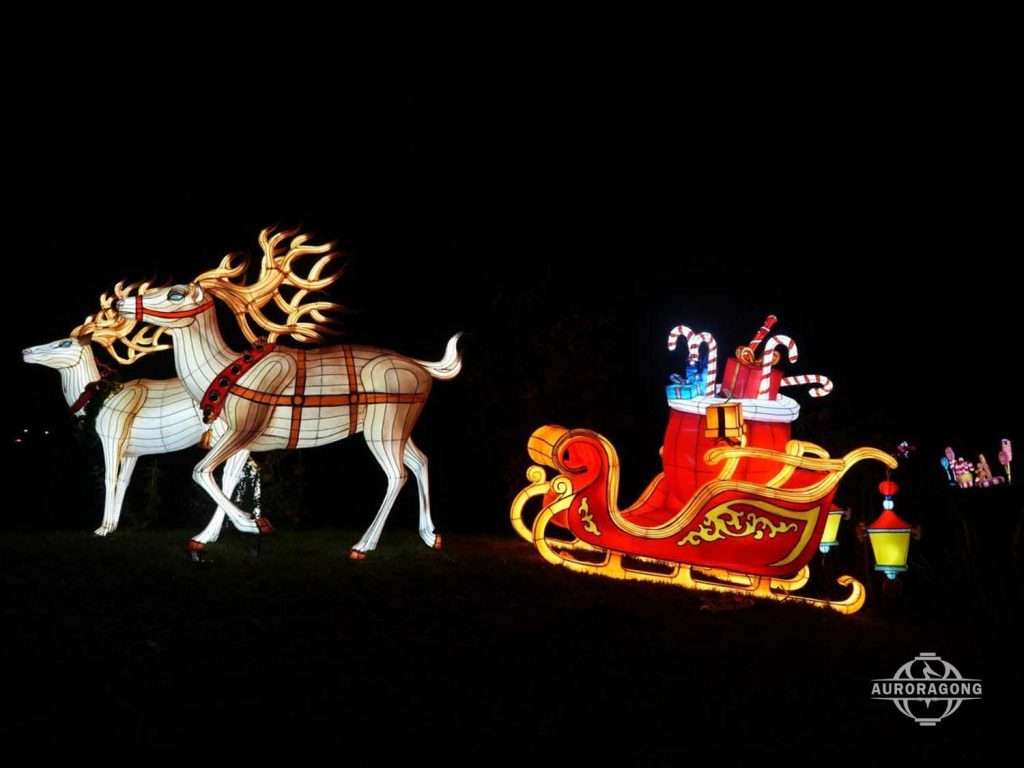 Illuminated Christmas scene with two white reindeer pulling Santa's sleigh with candy canes