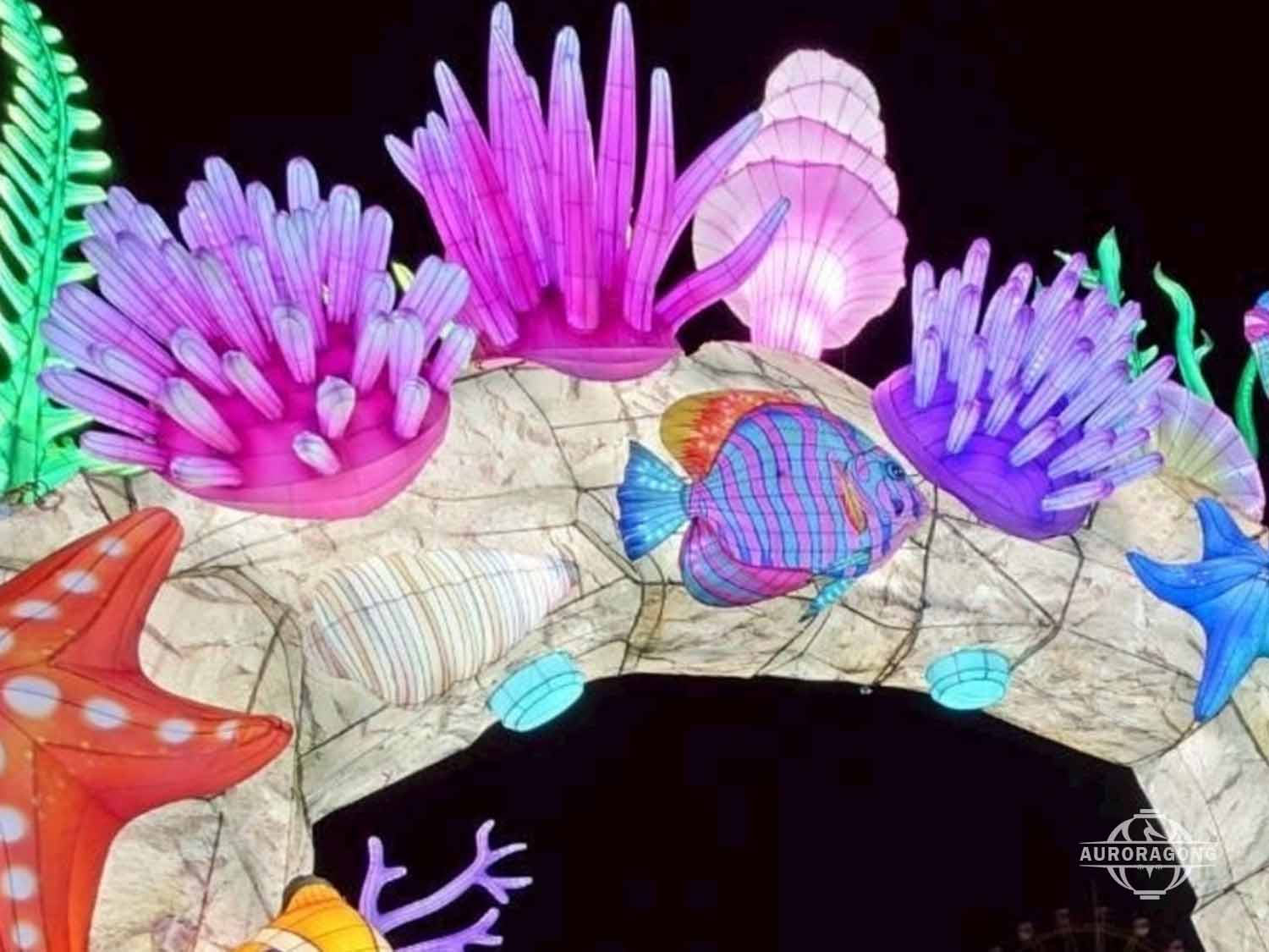 Close-up of illuminated ocean channel lantern with purple anemones, shells, starfish, and tropical fish