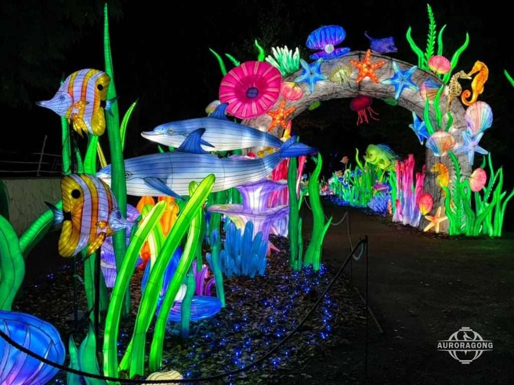 Illuminated ocean channel archway lantern with sharks, starfish, anemones, and octopus at night