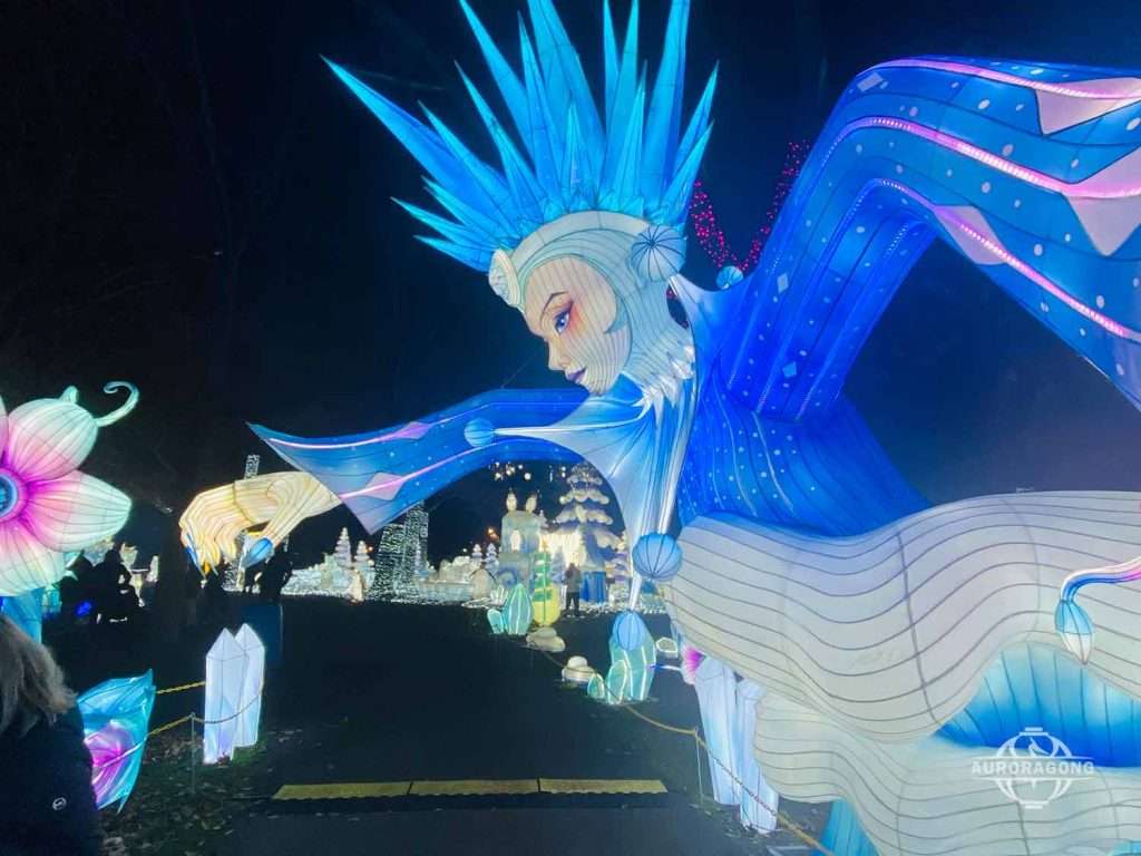 Illuminated ice queen character lantern with blue wings at a lumino city night festival