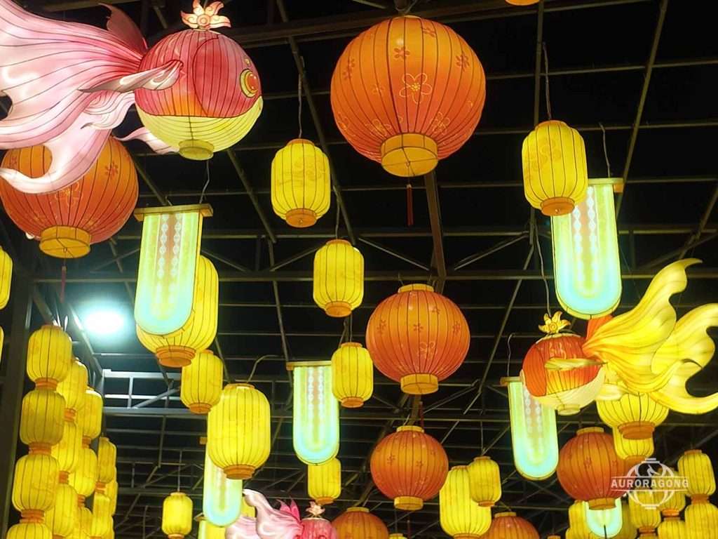 Indoor hanging lanterns with koi fish and round lanterns in yellow, red, and orange