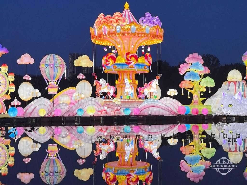 Colorful carousel lantern with hot air balloon and cloud lanterns reflected in a lake at night