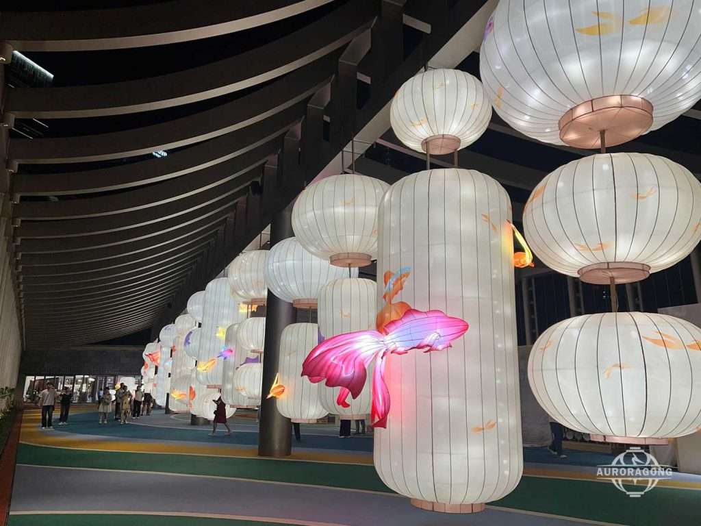 Long row of white round Chinese hanging lanterns in a shopping mall corridor with koi fish accents