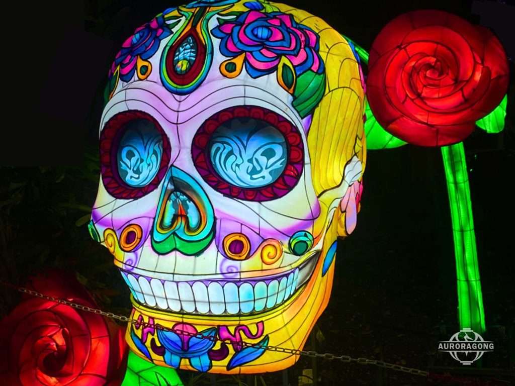 Colorful illuminated sugar skull Halloween lantern with intricate floral patterns and red rose decorations