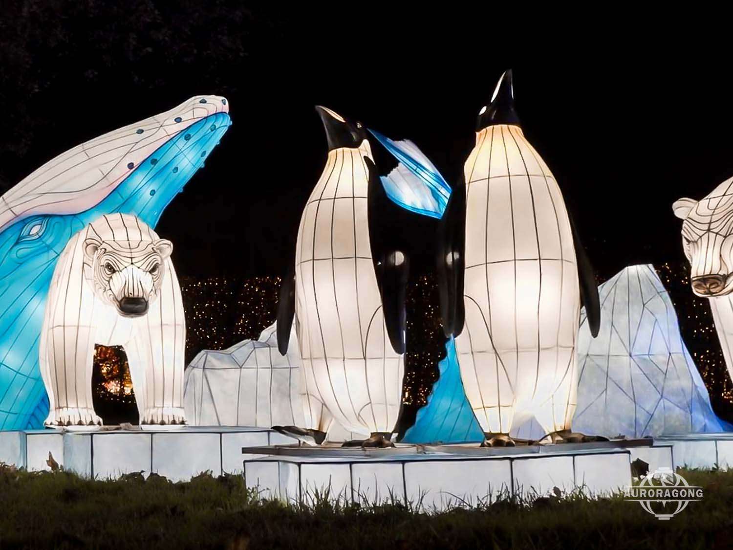 Polar bear and penguin lanterns on iceberg platform at night, Arctic light sculpture