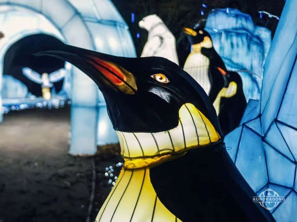 Close-up of penguin lantern showing internal steel frame and LED lighting, festival sculpture detail