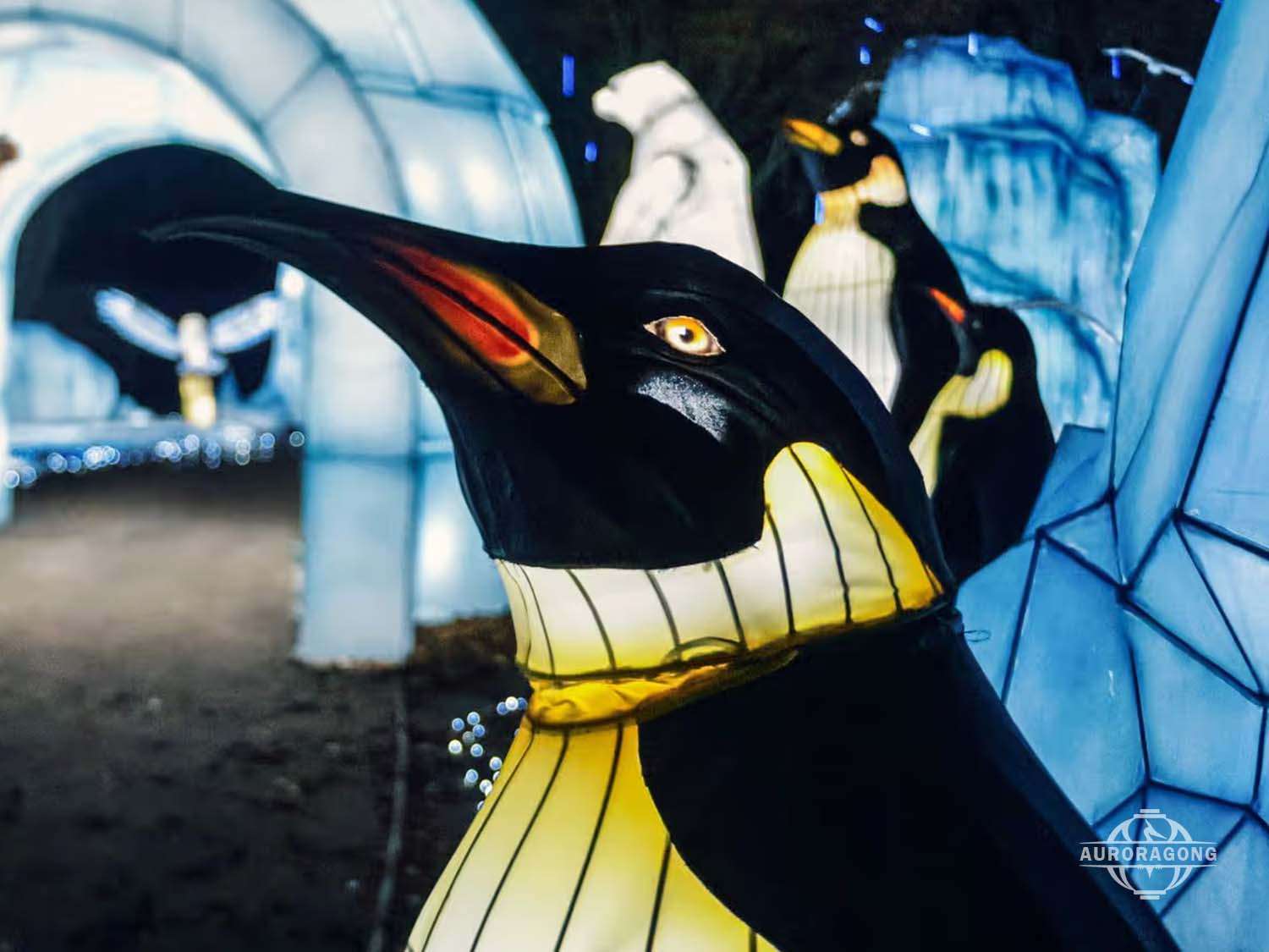 Close-up of penguin lantern showing internal steel frame and LED lighting, festival sculpture detail