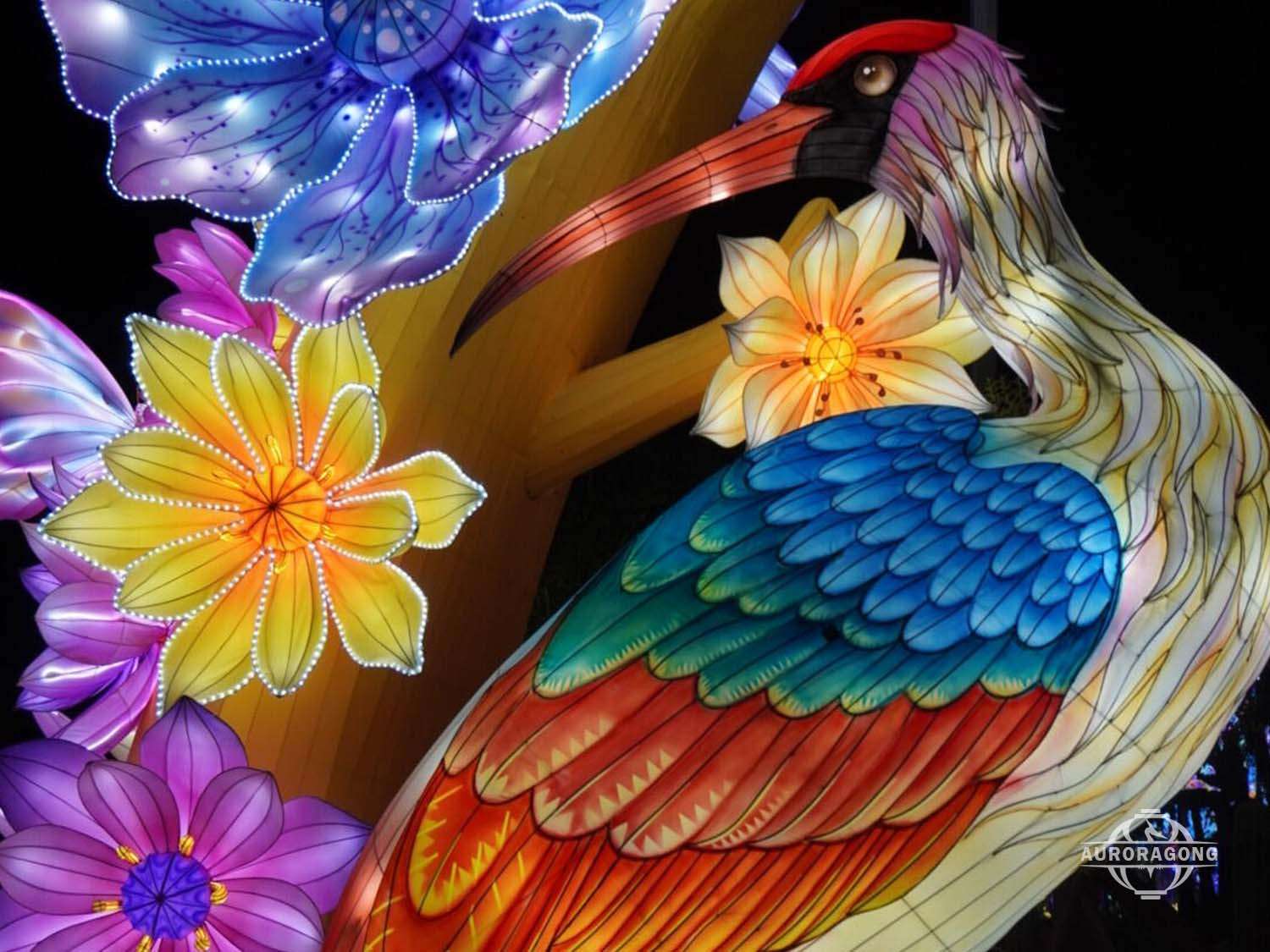 Detailed illuminated phoenix-like bird with multicolored feathers among pink flowers